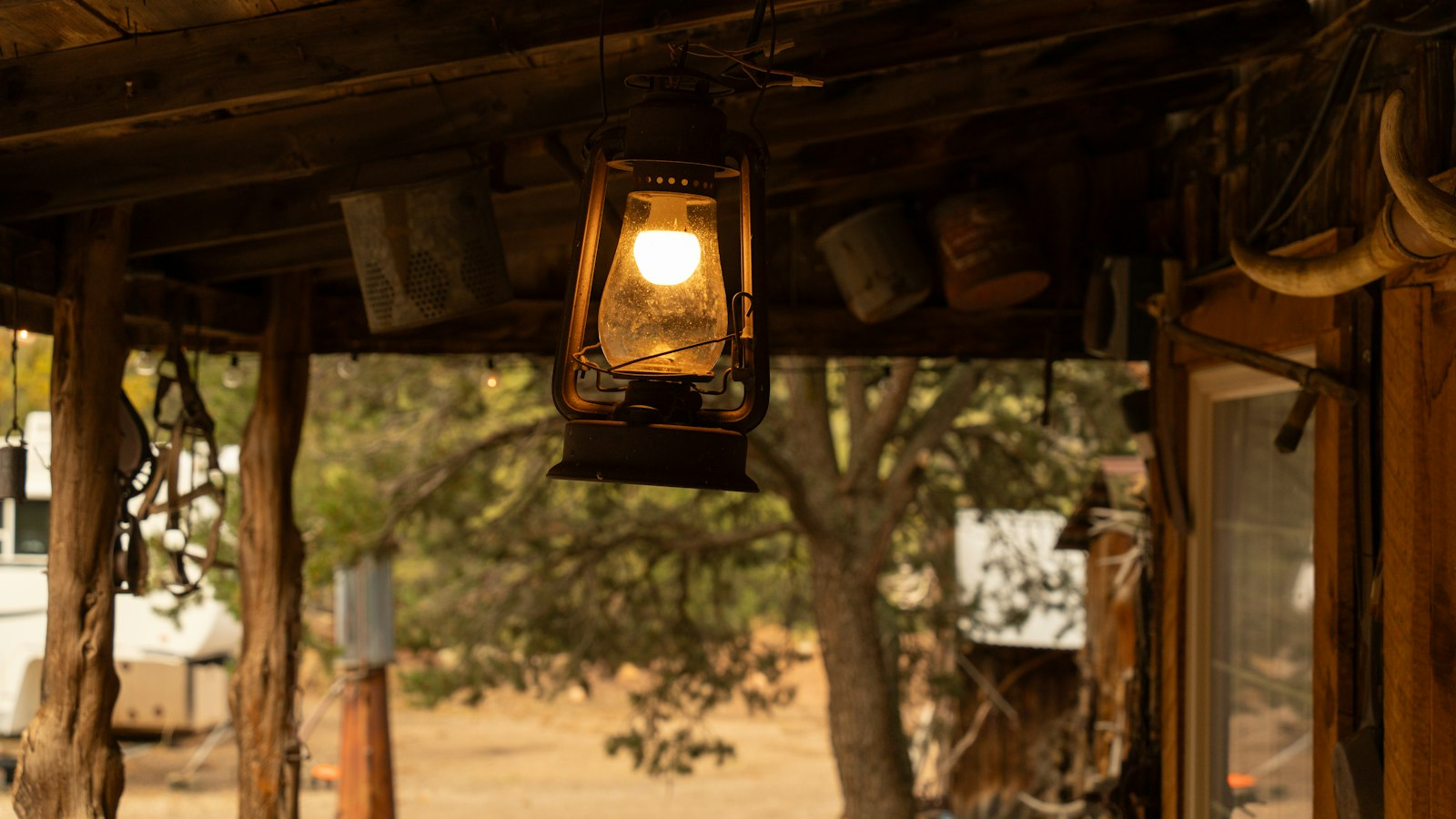 Metal lantern hanging on a rustic wooden porch