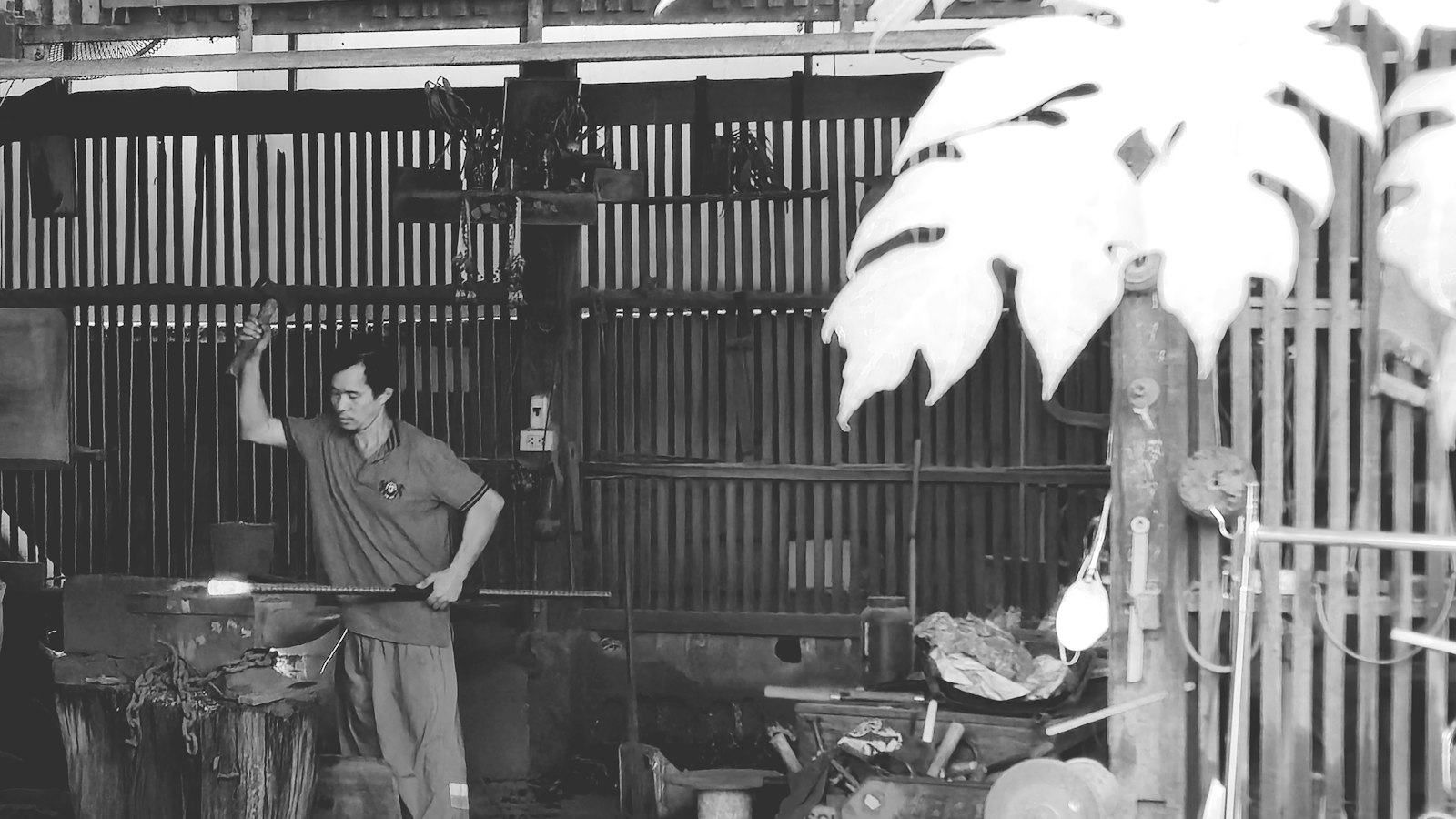 Metalworker at a workshop bench with tools and parts
